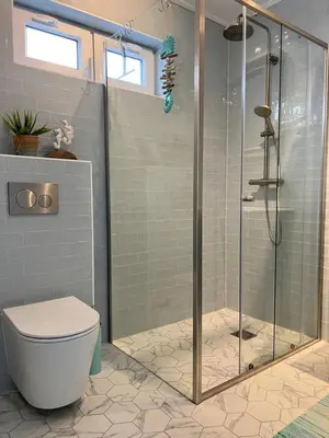 a bathroom with a toilet and a glass shower at The Coast Beach House in Egmond aan Zee