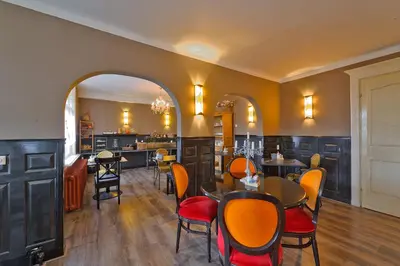 a dining room with tables and chairs and an archway at Mare Sanat in Wijk aan Zee