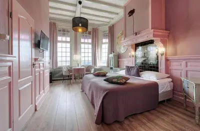 a bedroom with a large bed in a pink room at Mare Sanat in Wijk aan Zee