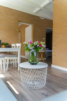 a vase of flowers sitting on top of a table at -Casa Nova- nabij het meer, duinen en restaurants in Noordwijkerhout