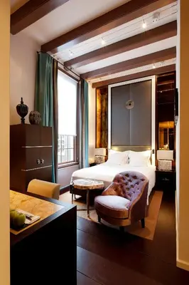 a bedroom with a bed and a large window at The Dylan Amsterdam - The Leading Hotels of the World in Amsterdam