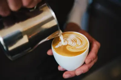 a person is pouring coffee into a cup at The Dylan Amsterdam - The Leading Hotels of the World in Amsterdam