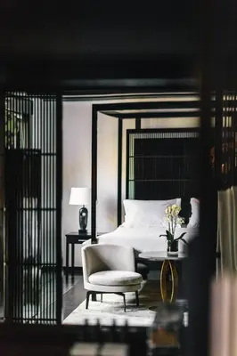 a bedroom with a bed and a chair and a table at The Dylan Amsterdam - The Leading Hotels of the World in Amsterdam