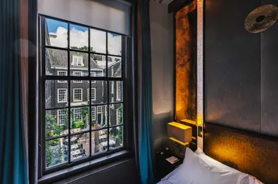 a bedroom window with a view of a building at The Dylan Amsterdam - The Leading Hotels of the World in Amsterdam