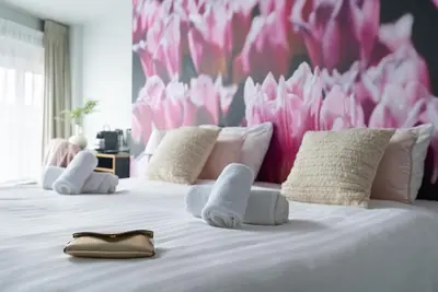 a child laying on a bed with a pink wall at Multatuli Hotel in Amsterdam