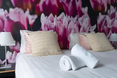 a bedroom with a bed with a flower wall at Multatuli Hotel in Amsterdam