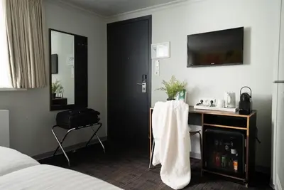 a hotel room with a bed and a desk and a television at Multatuli Hotel in Amsterdam