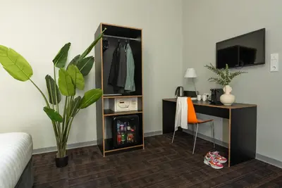 a room with a desk and a dresser with a mirror at Multatuli Hotel in Amsterdam