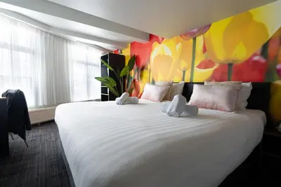 a large white bed in a room with colorful walls at Multatuli Hotel in Amsterdam