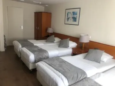 a room with three beds in a hotel room at Delta Hotel City Center in Amsterdam