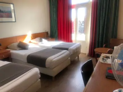 a hotel room with two beds and a window at Delta Hotel City Center in Amsterdam