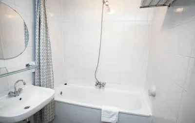 a white bathroom with a tub and a sink at Delta Hotel City Center in Amsterdam