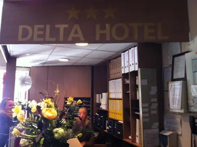 a hotel room with people sitting at a desk with flowers at Delta Hotel City Center in Amsterdam