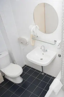 a white bathroom with a toilet and a sink at Delta Hotel City Center in Amsterdam