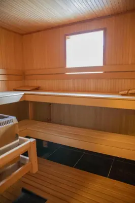 a sauna with a window and wooden panels at Villa de Nachtegaal in Naarden