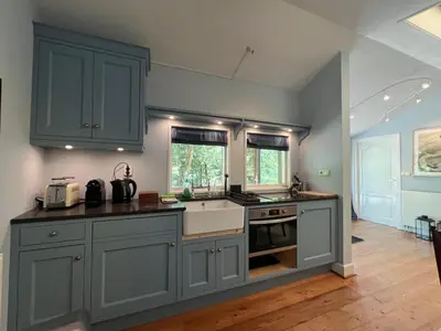 a kitchen with gray cabinets and a sink at Villa de Nachtegaal in Naarden