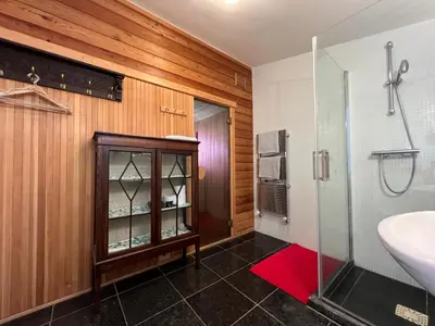a bathroom with a sink and a glass shower at Villa de Nachtegaal in Naarden