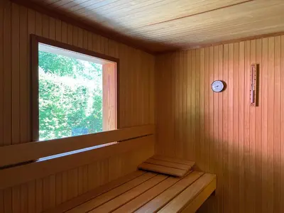 a sauna with a window and a clock on the wall at Villa de Nachtegaal in Naarden