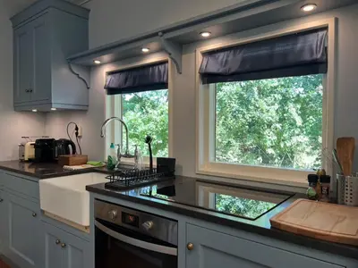 a kitchen with a sink and a window at Villa de Nachtegaal in Naarden