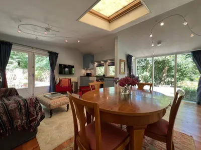 a dining room with a table and a living room at Villa de Nachtegaal in Naarden