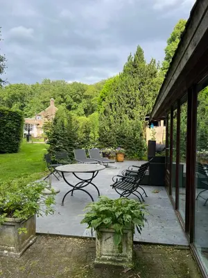 a patio with a table and chairs and trees at Villa de Nachtegaal in Naarden