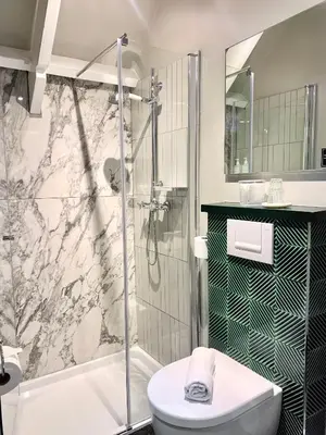a bathroom with a shower and a toilet and a sink at Boutique hotel Villa Trompenberg in Hilversum
