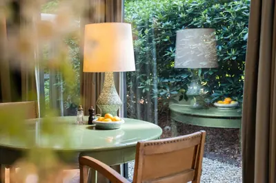 a table with a lamp and a bowl of oranges on it at Boutique hotel Villa Trompenberg in Hilversum