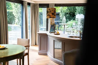 a kitchen with a sink and a table and a table and chairs at Boutique hotel Villa Trompenberg in Hilversum