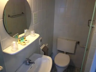 a bathroom with a sink and a toilet and a mirror at Amadeus Hotel in Haarlem