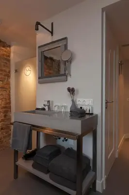 a bathroom with a sink and a mirror and towels at Mother Goose Hotel in Utrecht