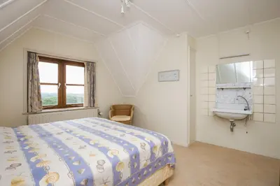 a bedroom with a bed and a sink at Villa de Duintop in Bergen aan Zee