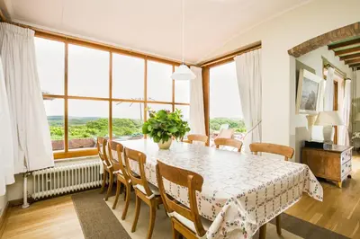 a dining room with a table and chairs and large windows at Villa de Duintop in Bergen aan Zee