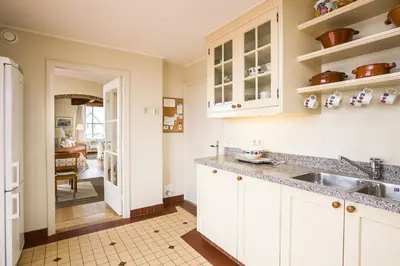 a kitchen with white cabinets and a sink at Villa de Duintop in Bergen aan Zee