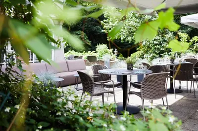 a patio with a table and chairs and a couch at Kasteel Kerckebosch in Zeist