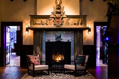 a living room with a fireplace with chairs and a table at Kasteel Kerckebosch in Zeist