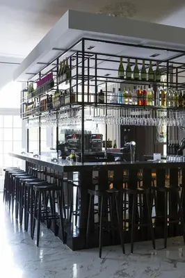 a bar with black bar stools in a room at Kasteel Kerckebosch in Zeist