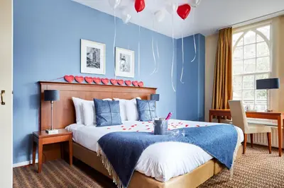 a bedroom with a large bed with blue walls at Kasteel Kerckebosch in Zeist
