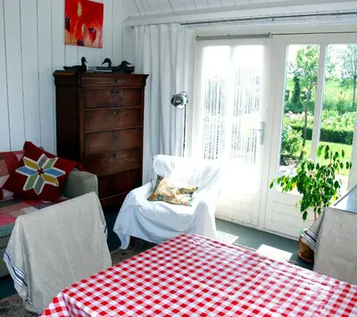 a room with a table and a chair and a window at Bed In Waterland in Broek in Waterland