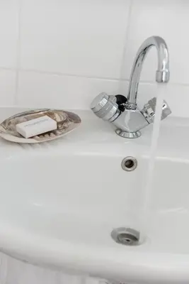 a sink with a faucet and a plate with a book at Hotel Zonne in Noordwijk aan Zee