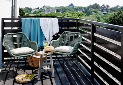 two chairs and a table on a balcony at Hotel Zonne in Noordwijk aan Zee