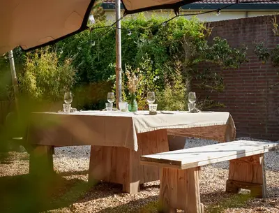 a table with wine glasses on it under an umbrella at Hotel Zonne in Noordwijk aan Zee