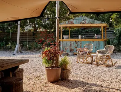 a patio with a table and chairs and an umbrella at Hotel Zonne in Noordwijk aan Zee