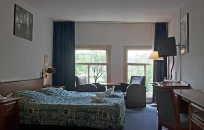 a hotel room with a bed with a stuffed animal on it at Hotel Prins Hendrik in Amsterdam