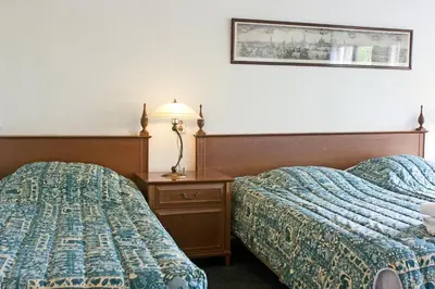 a hotel room with two beds and a table with a lamp at Hotel Prins Hendrik in Amsterdam