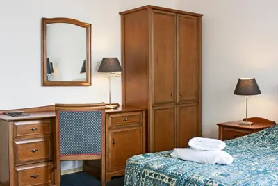 a bedroom with a bed and a dresser and a mirror at Hotel Prins Hendrik in Amsterdam