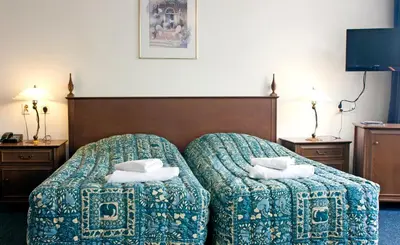 a hotel room with a bed and two ottomans at Hotel Prins Hendrik in Amsterdam