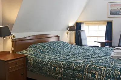 a bedroom with a bed with a blue blanket and a window at Hotel Prins Hendrik in Amsterdam