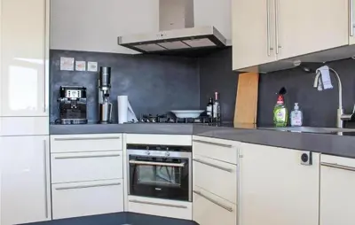 a kitchen with white cabinets and a stove top oven at Duinzicht 2 in Bergen aan Zee