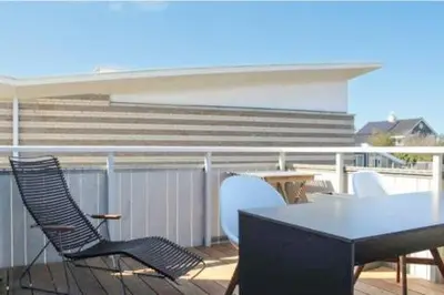 a table and chairs on a balcony with stairs at Duinzicht 2 in Bergen aan Zee