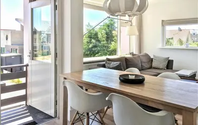 a living room with a wooden table and chairs at Duinzicht 2 in Bergen aan Zee